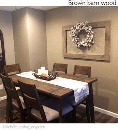 a dining room table and chairs with a wreath on the wall