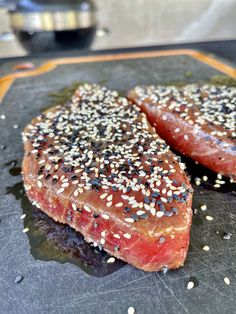 two pieces of meat with sesame seeds on them