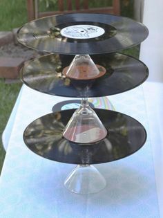 three records are stacked on top of each other at an outdoor table with grass in the background