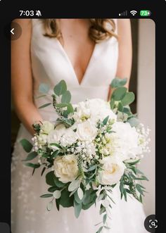 a bridal holding a bouquet of white flowers and greenery