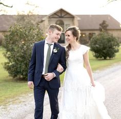 a bride and groom are walking down the road