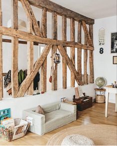 a living room filled with furniture and lots of wooden beams on the wall above it