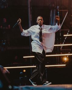 a man in white shirt and tie on stage