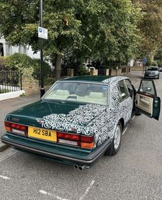 a green car parked on the side of a road