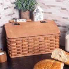 some bread is sitting on a table next to a potted plant and a house shaped sign