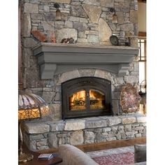 a stone fireplace in a living room with two lamps on either side of the fire place