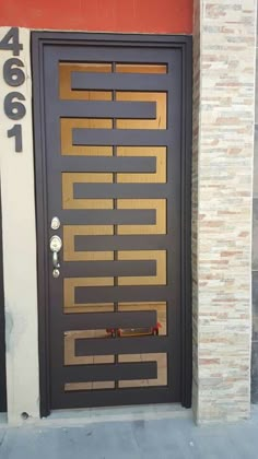 a black door with gold foiling on the side of a brick building and number 466