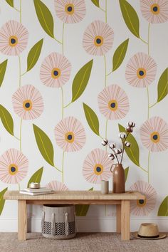 a wooden bench sitting in front of a wall with flowers on it and green leaves