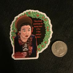 a penny sitting next to a sticker with an image of frida