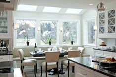 a kitchen filled with lots of counter top space next to a dining room table and chairs