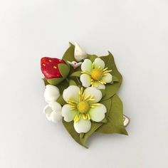 a bouquet of white and yellow flowers on top of green leaves