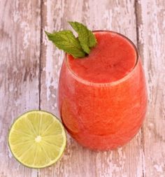 a close up of a drink on a table with a slice of lime next to it