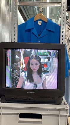 a woman's blue shirt is on display in front of a television