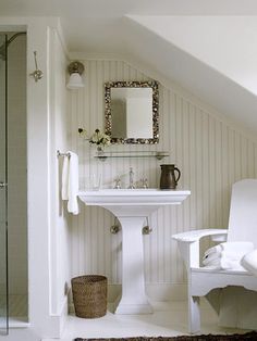 an attic bathroom with white fixtures and striped walls