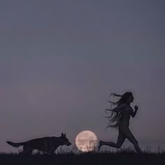 a woman running next to a wolf at night