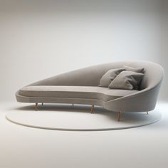 a curved couch with pillows on it sitting in front of a white wall and floor