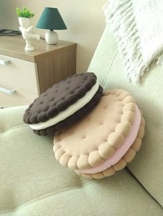 three cookies sitting on top of each other on a couch in front of a lamp