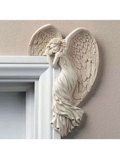 an angel figurine hanging on the side of a wall