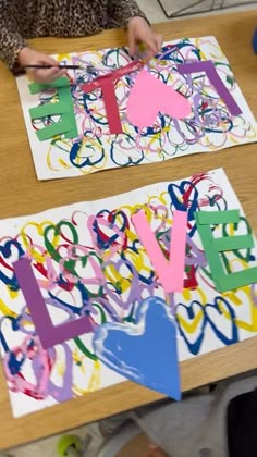 two children are making paper letters with scissors