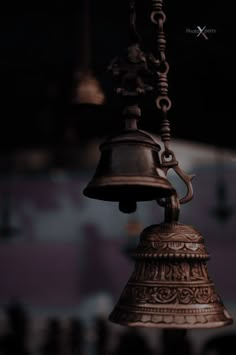 a bell hanging from a chain in the dark