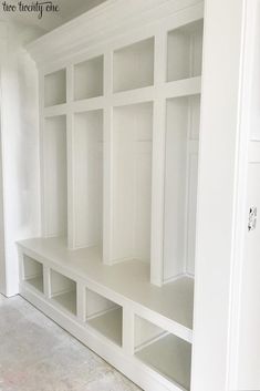 an empty room with white shelving in it