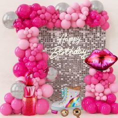 a birthday party with pink balloons, lipstick, and boots on the floor in front of a photo frame