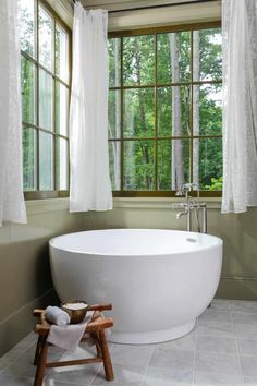 a large white bath tub sitting next to a window