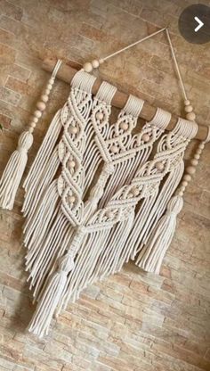 a wall hanging made out of macrame and wood beads with tassels