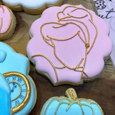 some cookies that are decorated like princesses and pumpkins on a wooden table with other decorations