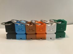 four different colors of keychains on a white surface with one in the middle