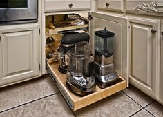 an open drawer in a kitchen filled with appliances