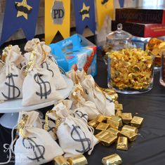 a table topped with lots of bags filled with gold bars and candy bar wrappers