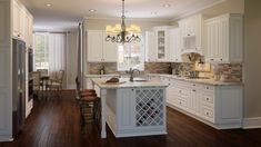 a large kitchen with white cabinets and wood floors