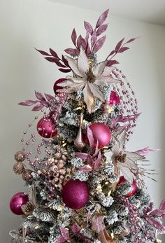 a christmas tree decorated with pink and silver ornaments