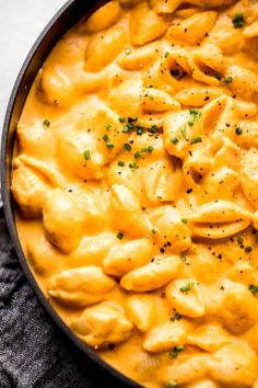 a pan filled with macaroni and cheese on top of a table next to a napkin