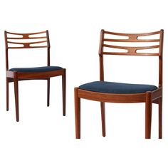 two wooden chairs with blue upholstered seat cushions on each one and the other side