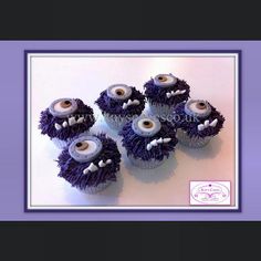 four cupcakes with googly eyes and fangs on them are sitting in front of a purple frame