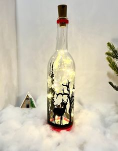 a bottle with some lights in it sitting on top of snow