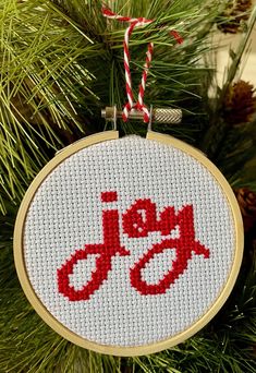 a cross stitch ornament hanging from a christmas tree