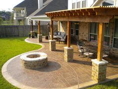 an outdoor patio with a fire pit and seating area