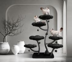 two cats sitting on top of black and white sculptures