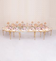 a table with flowers on it in front of a wall