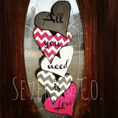 the door is decorated with hearts and saying all you need is love in pink, white, gray and black