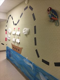 a hallway decorated with toilet paper and an ocean scene on the wall next to it