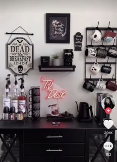 there is a coffee bar with various items on the table and shelves above it that are decorated with signs