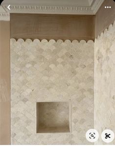 the bathroom is decorated in white and has an open niche on the wall with scallops