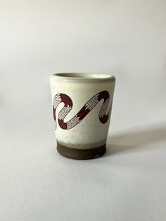 a white and red cup sitting on top of a table