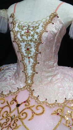 a pink and gold ball gown is on display