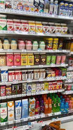 an assortment of milk and juices on display in a grocery store