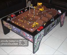 a table with cars and trucks on it in the middle of a floored room